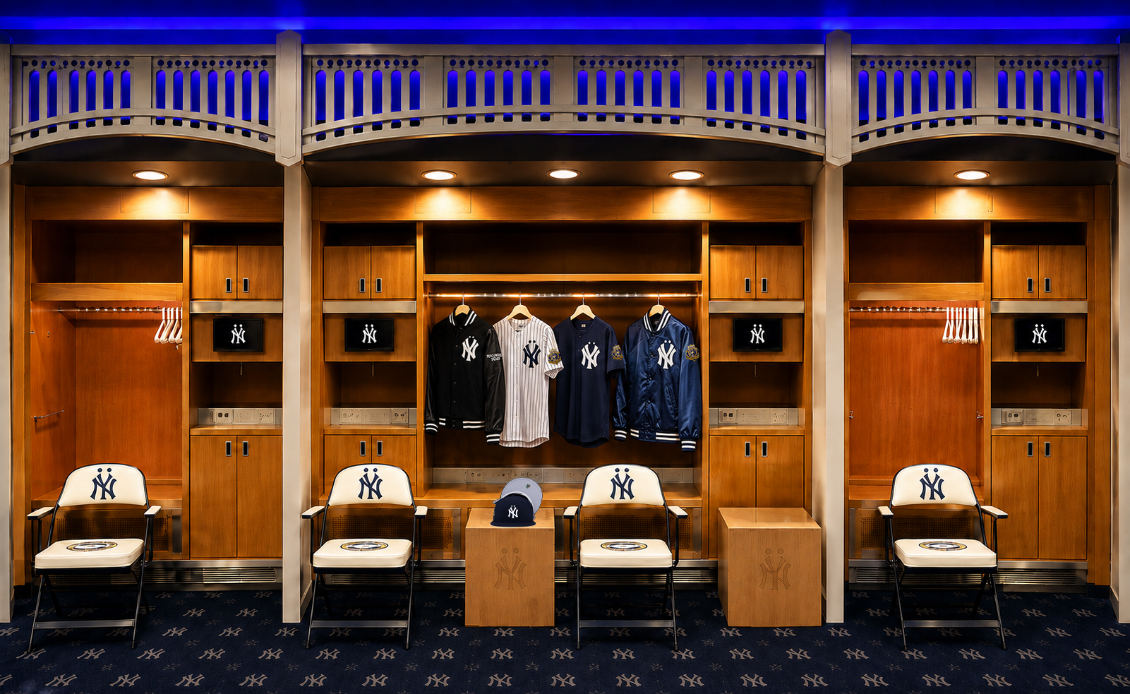 Yankee Stadium locker room with hanging jerseys, cap, and chairs